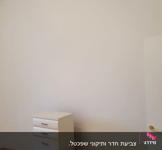 קיר צבוע בלבן עם רהיטים לבנים